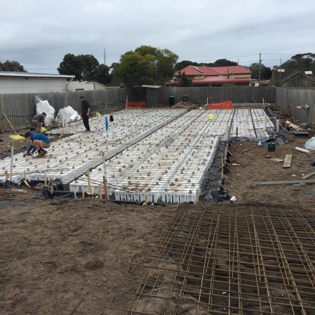 Workers in action preparing large area for concreting